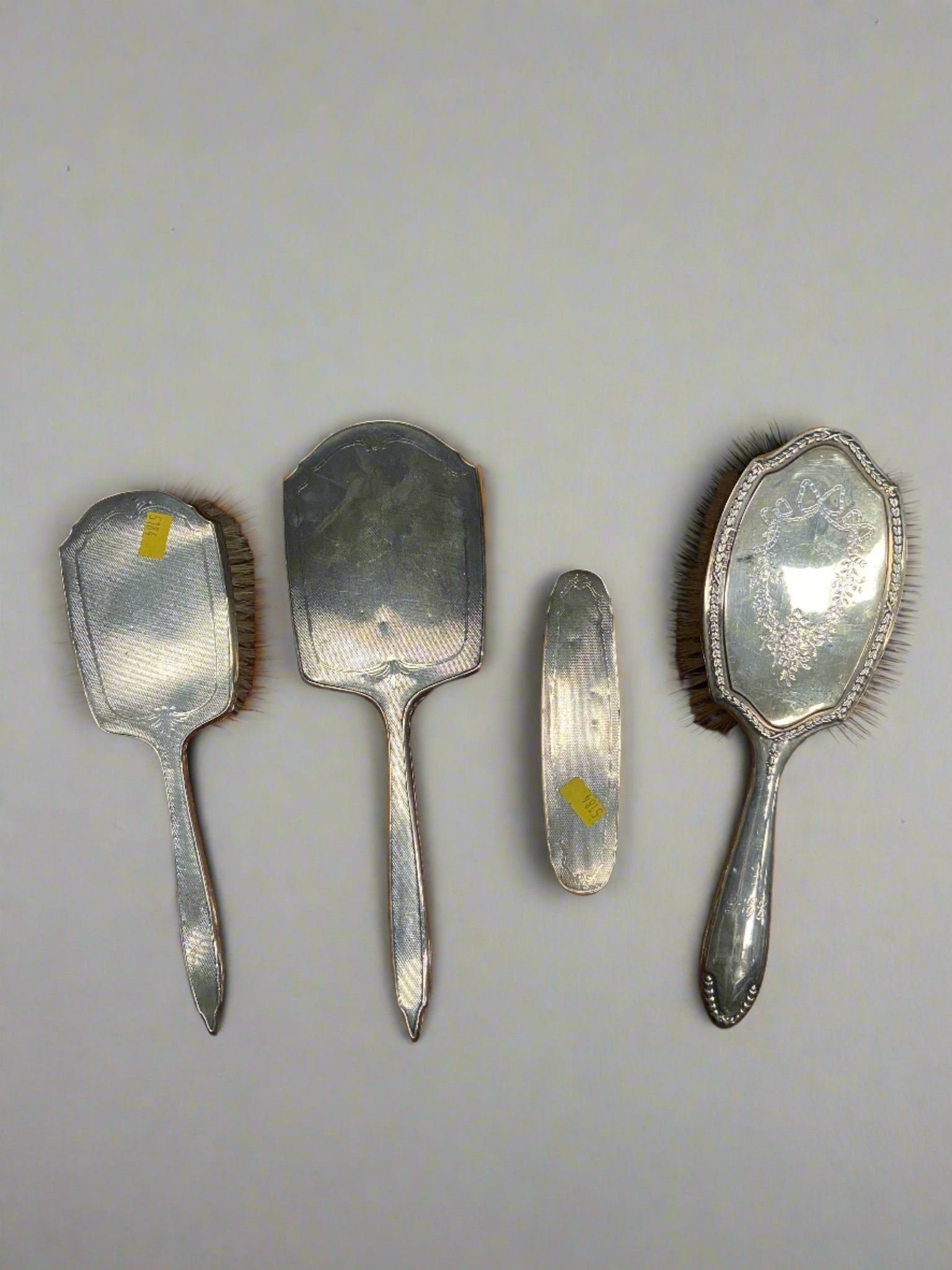 Victorian silver engraved four-piece brush and mirror vanity set.