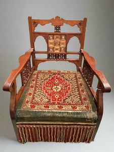 Colourful tapestry chair with a wooden beaded frame and long hanging trim.