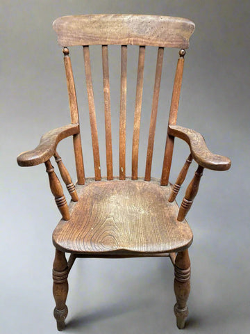 Large antique wooden Windsor armchair with a slatted back. Likely Victorian.