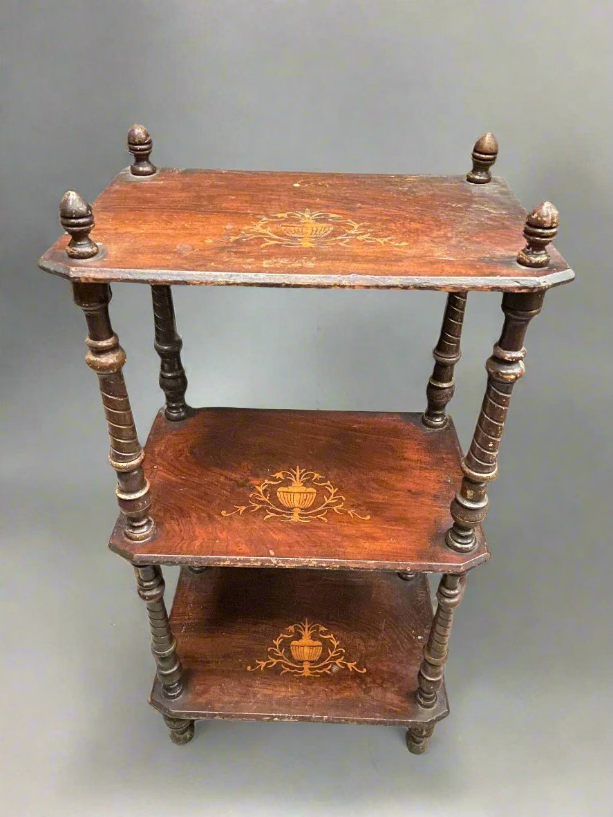 Three shelved wooden storage unit with an inlaid wood design featuring a pot with leaves and twisted spindle supports.