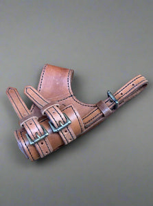 Brown leather gun holster with metal buckles.