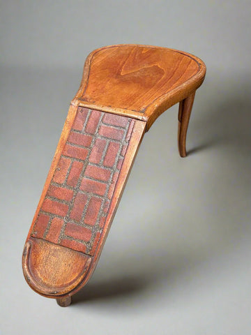 Wooden shoe fitting stool covered with a vinyl brick pattern. Circa 1940s.