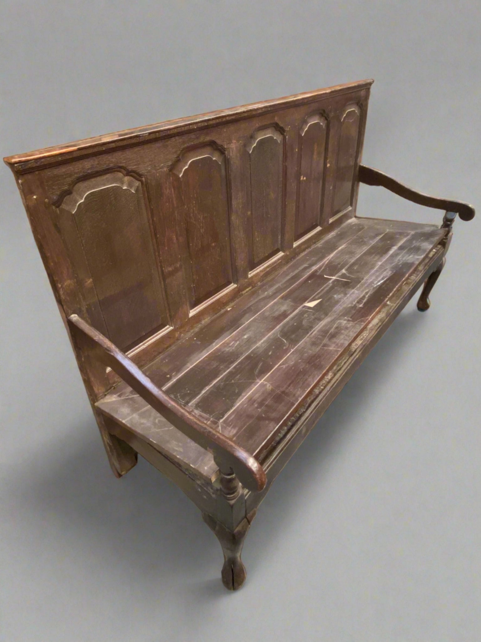 Wide dark wooden church-style bench/pew with a high back of five fielded panels.