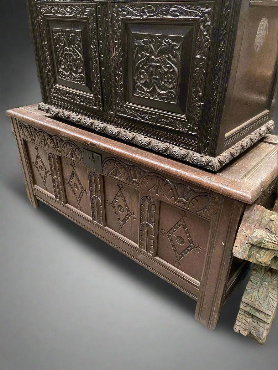 Wide storage chest hand crafted from a mid-brown wood and decorated with diamond shaped carvings.