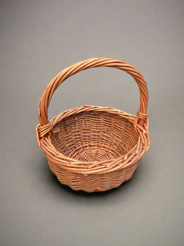 Round storage basket with a thick woven handle, made from stained wicker.