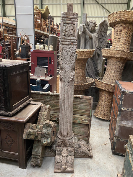 A pair of tall carved decorative columns with an ornate cross-shaped base and top.