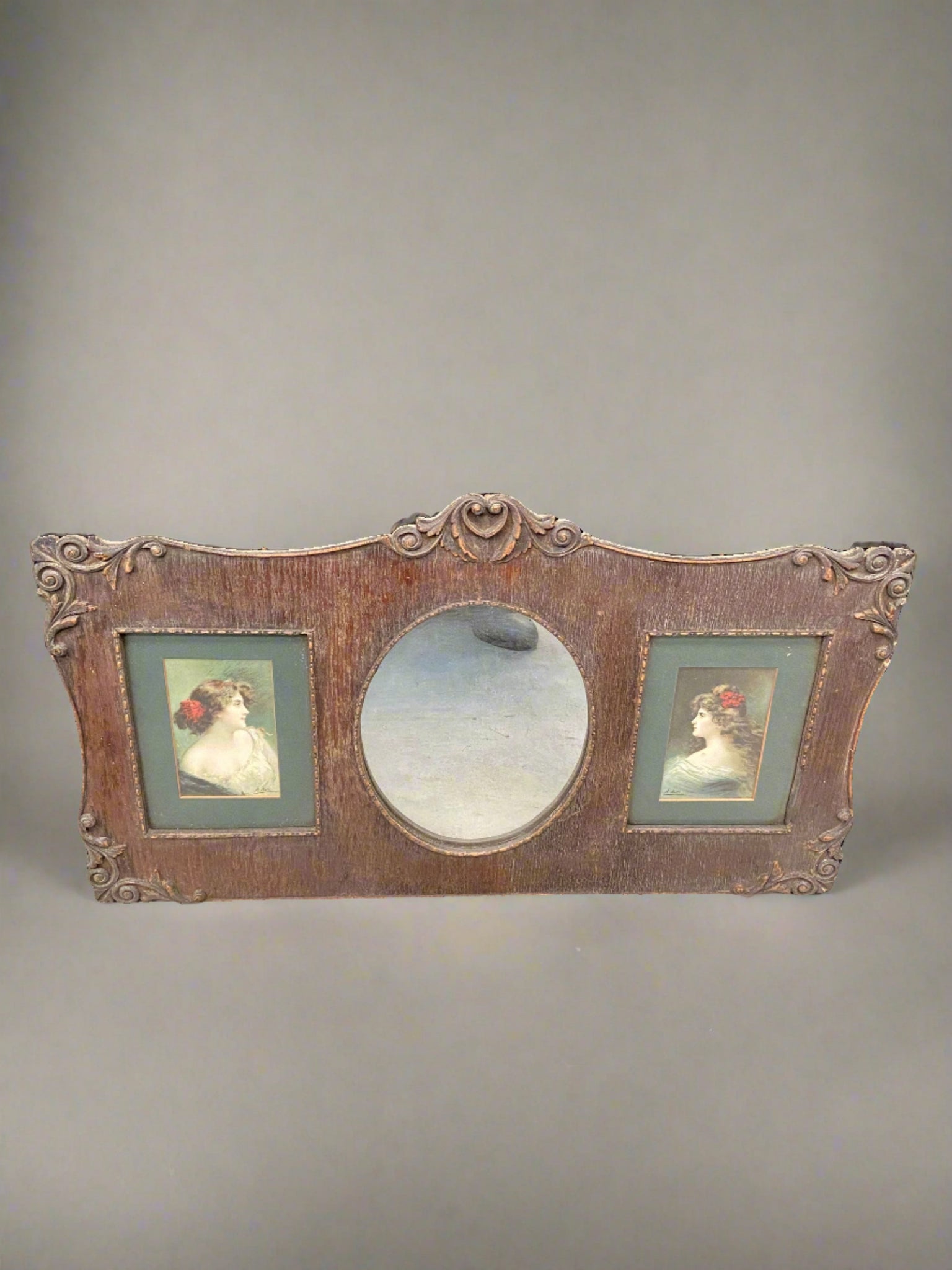 Double rectangular picture frame set inside an ornate wooden frame with a central oval mirror.