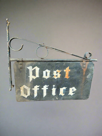 Antique hanging post office sign; white gothic-style font hand painted onto a black metal backboard.