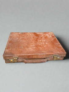 Shallow brown leather suitcase with mildew.