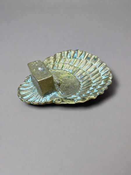 Antique brass ashtray in the shape of a seashell with a gorgeous aged patina. The rectangular block would hold the cigarette packet and partly push it open.