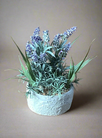 Faux plastic lavender plant in a grey pot.