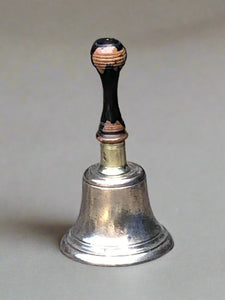 Silver handbells with worn black wooden handles.