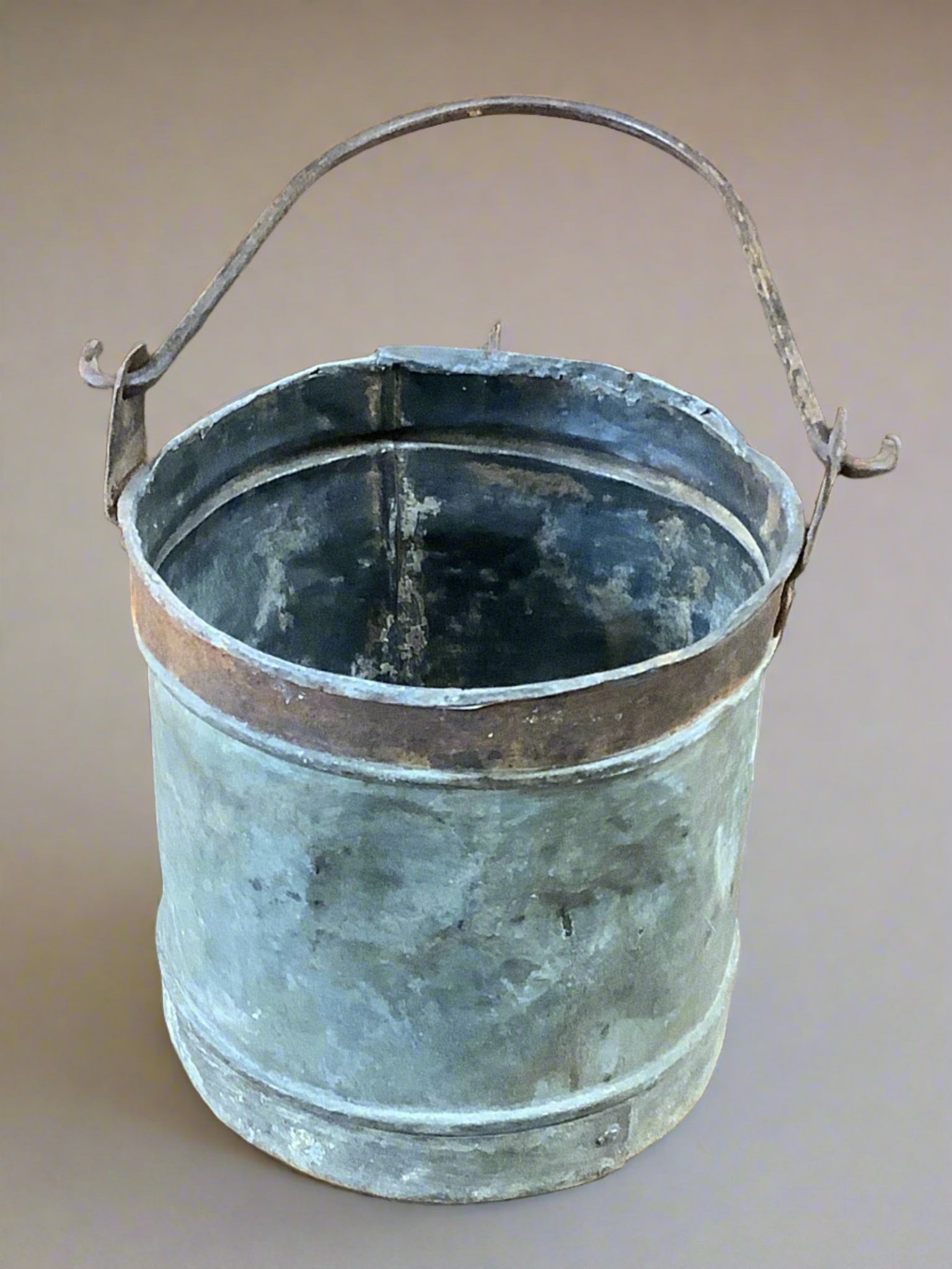 Steel metal bucket with copper banding and a curved metal handle.