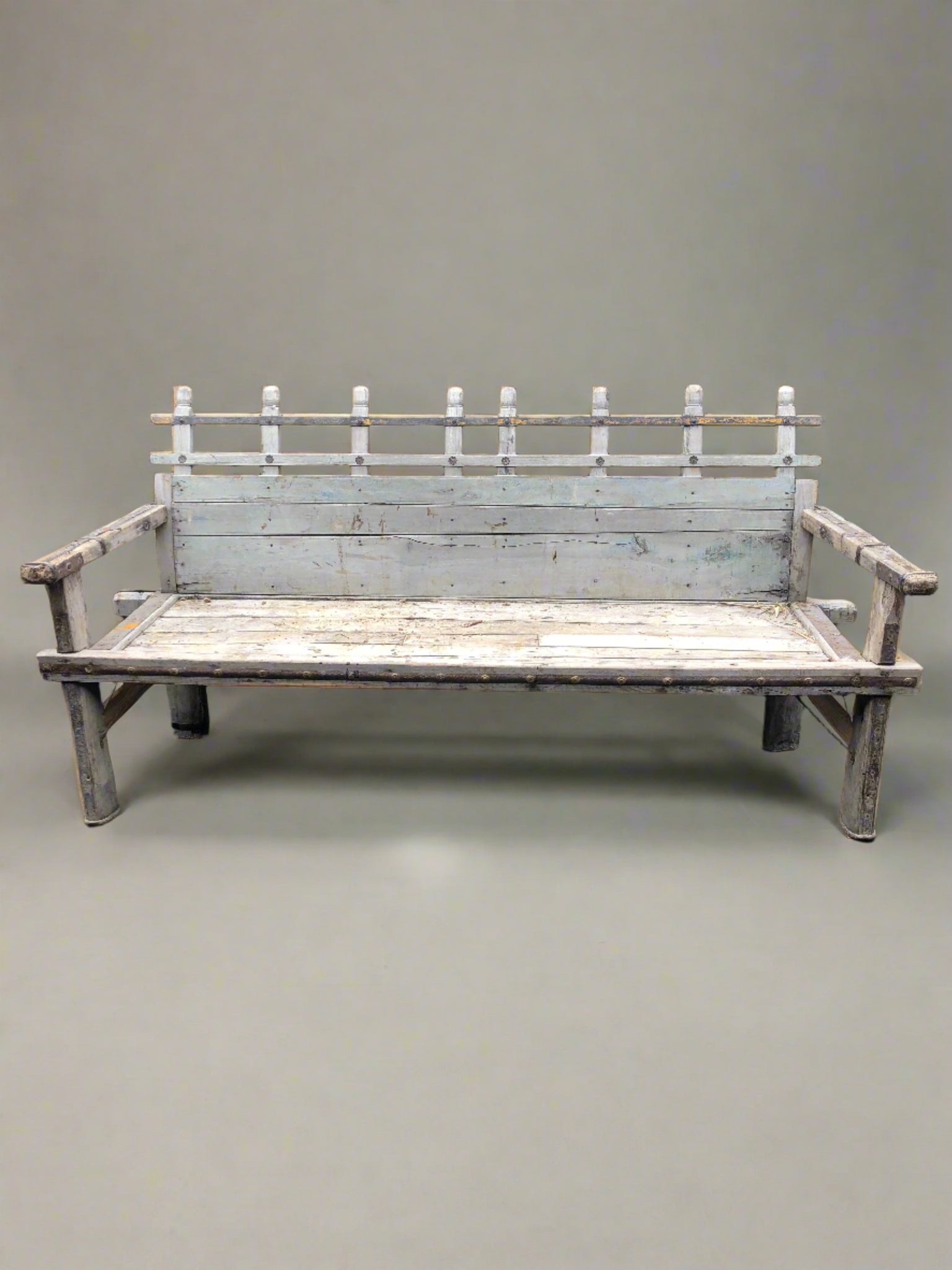 Medieval style wooden bench with unusual slatted detail to seat back, metal band trims and studding.