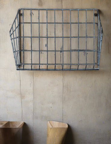 Angled wall-mounted hay rack constructed from wire.