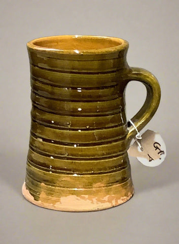 Large earthenware tankard with mottled green gloss glazing, ribbed design and handle.