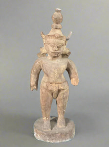 Hand-carved wooden sculpture of Vishnu in primitive style.