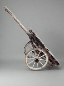 Simple rustic wooden hand cart with handles.  Some damage to wood, commensurate with primitive feel.
