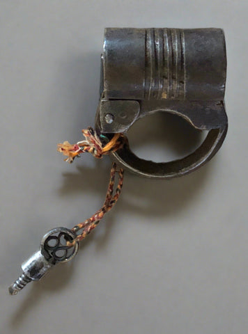 Small ornate barrel-shaped Indian padlock with a key on typically Indian style colourful woven threads.