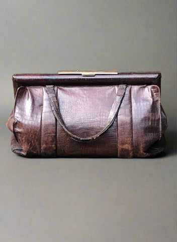 1940s-style crocodile skin handbag with brass hardware and loop handle.