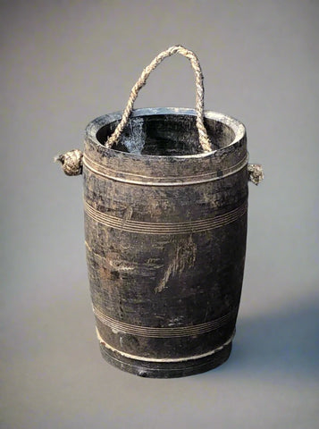 Tall and narrow wooden bucket with rope handle. Used for water carrying.