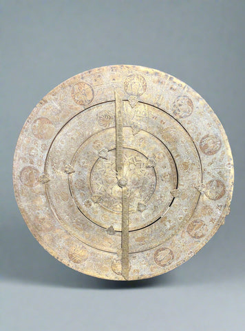Intricately detailed brass sundial with engraved astrological design.